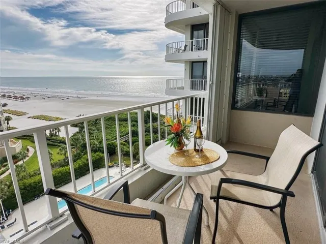 Balcony featuring view of water and beach