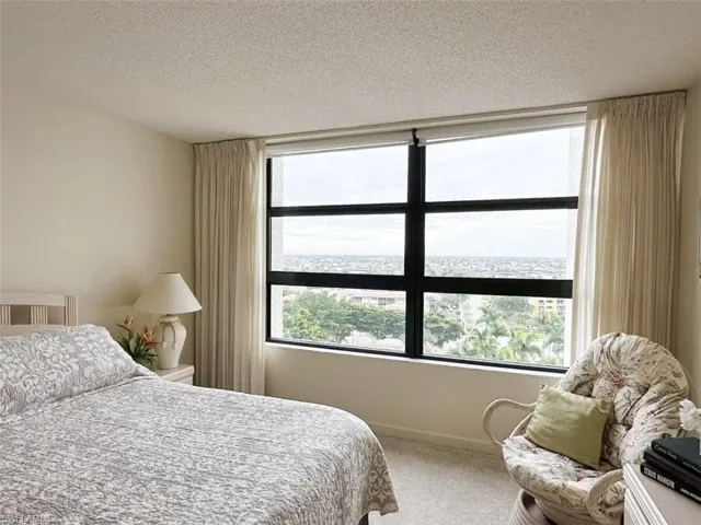 Bedroom with a textured ceiling and carpet floors