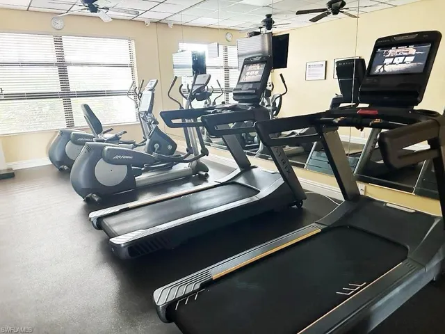 Workout area featuring ceiling fan and a paneled ceiling