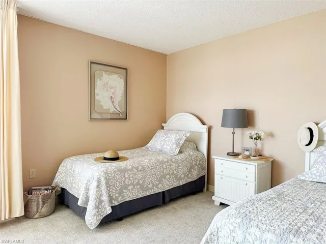 Bedroom with light carpet and a textured ceiling