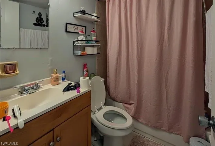 Full bathroom featuring vanity, shower / tub combo, and toilet