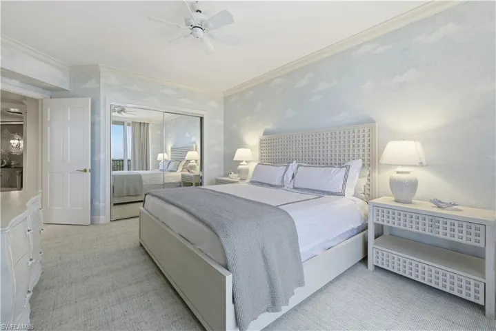 Bedroom with light colored carpet, a closet, crown molding, a ceiling fan, and wallpapered walls
