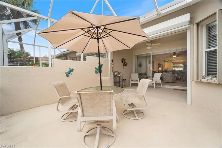 View of patio with a lanai, outdoor dining area, and ceiling fan
