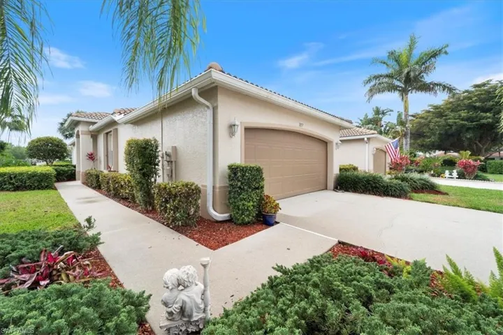 View of home's exterior with stucco siding, concrete driveway, an attached garage, and a tiled roof