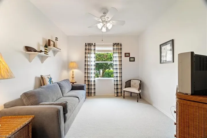 Living room with light colored carpet, baseboards, and ceiling fan