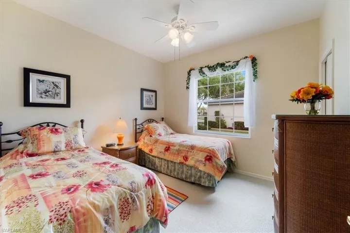 Carpeted bedroom featuring a ceiling fan and baseboards