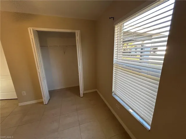 Unfurnished bedroom featuring a closet and light tile patterned floors