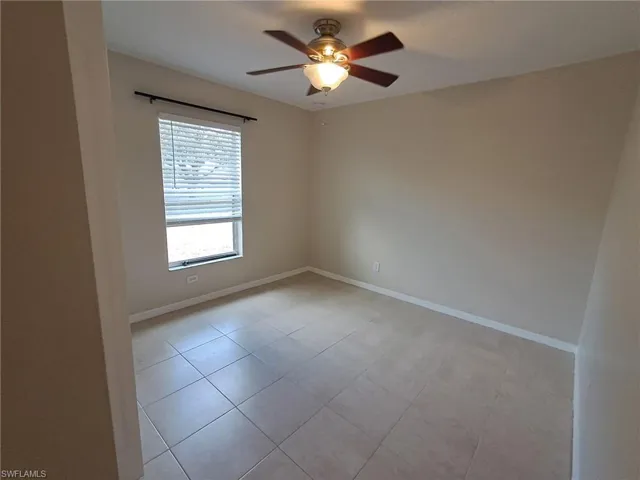 Spare room featuring light tile patterned floors and a ceiling fan