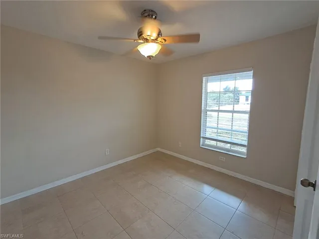 Unfurnished room featuring a ceiling fan and light tile patterned floors