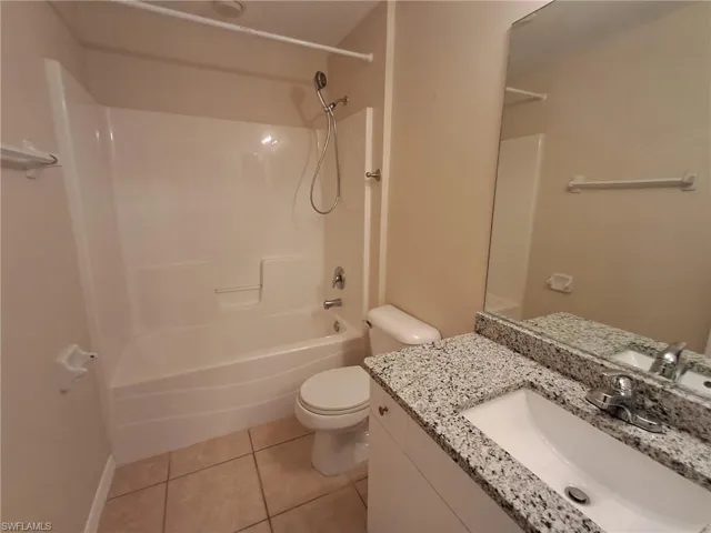 Bathroom with vanity, light tile patterned floors, and shower / tub combination