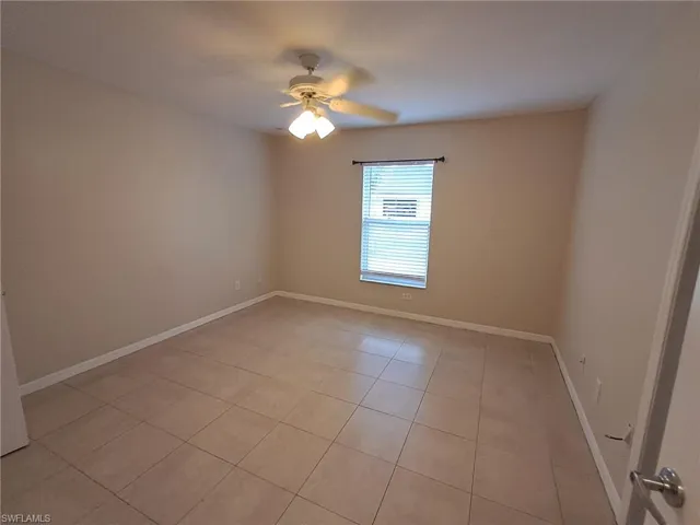 Spare room with light tile patterned flooring and ceiling fan