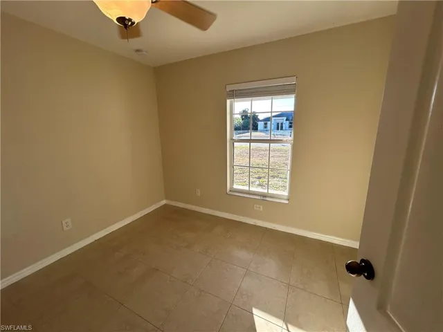 Unfurnished room featuring light tile patterned flooring and a ceiling fan