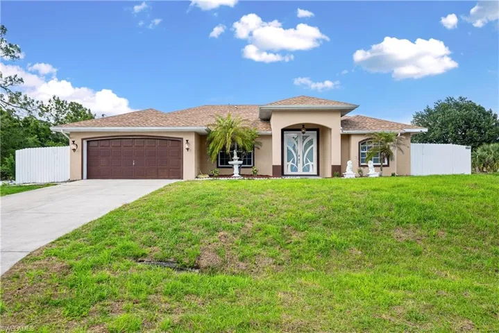 View of front of property featuring an attached garage, stucco siding, and concrete driveway