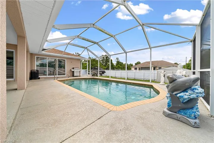 Outdoor pool with a sunroom, a patio area, a lanai, and area for grilling