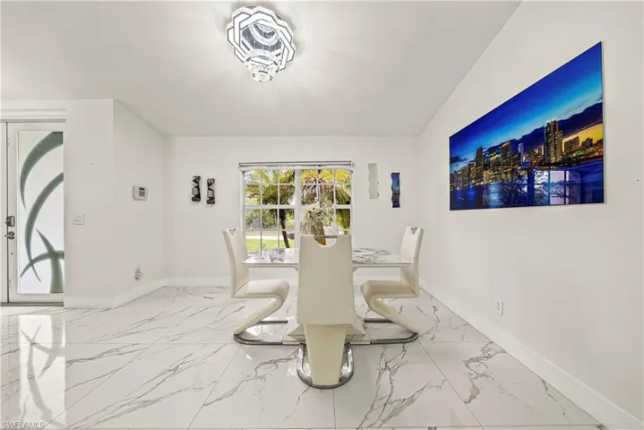 Dining space with light marble finish flooring and baseboards