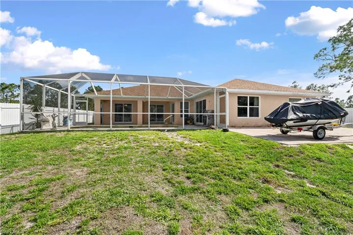 Back of property featuring glass enclosure, a sunroom, a patio area, and stucco siding