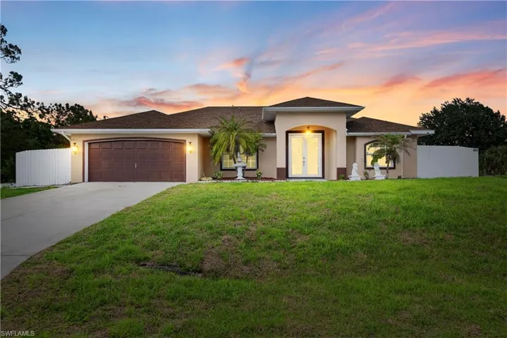 View of front of house featuring an attached garage, stucco siding, and driveway