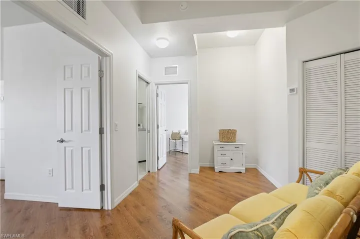 Sitting room with baseboards, light wood finished floors, and visible vents