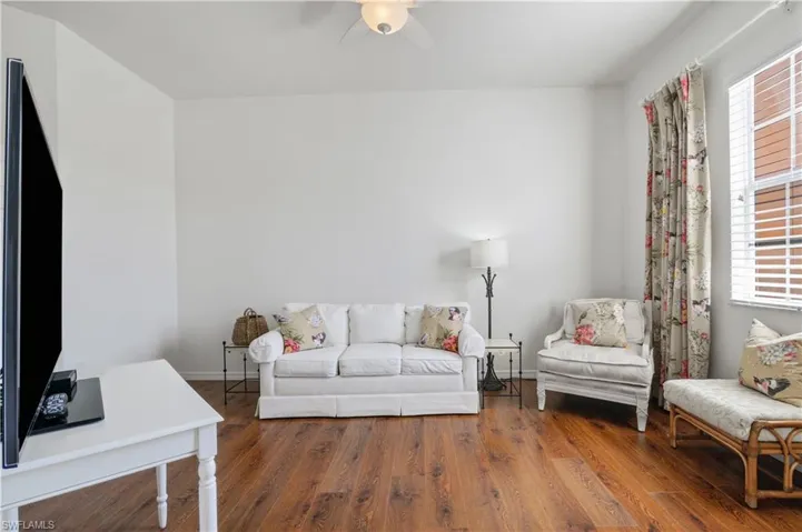 Living area featuring baseboards, ceiling fan, and wood finished floors
