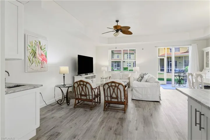 Living room featuring light wood-style flooring, baseboards, and a ceiling fan