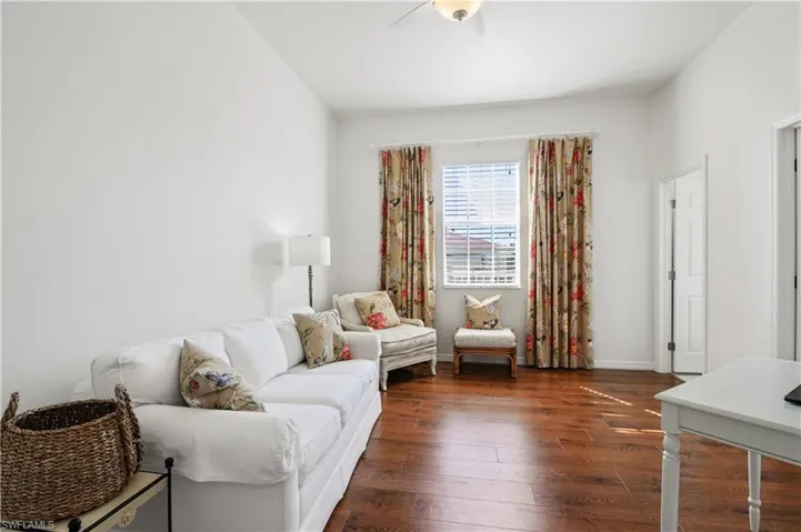 Living room featuring dark wood-style floors and a ceiling fan