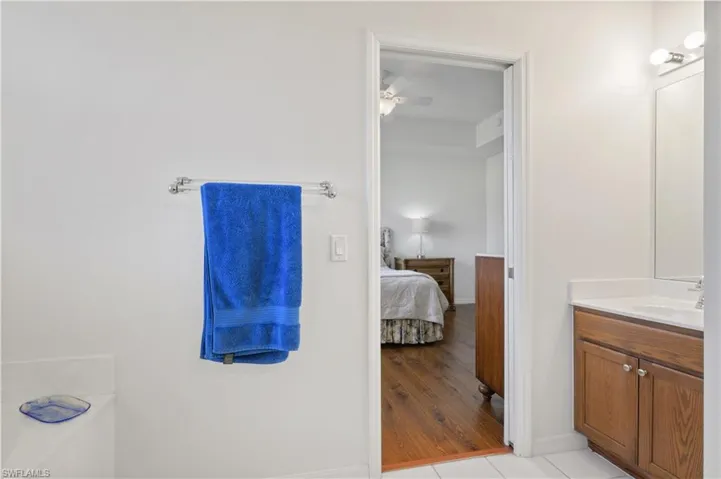Bathroom featuring connected bathroom, a ceiling fan, baseboards, and vanity