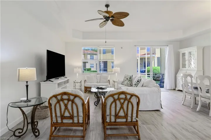 Living area featuring light wood-style floors, baseboards, and ceiling fan