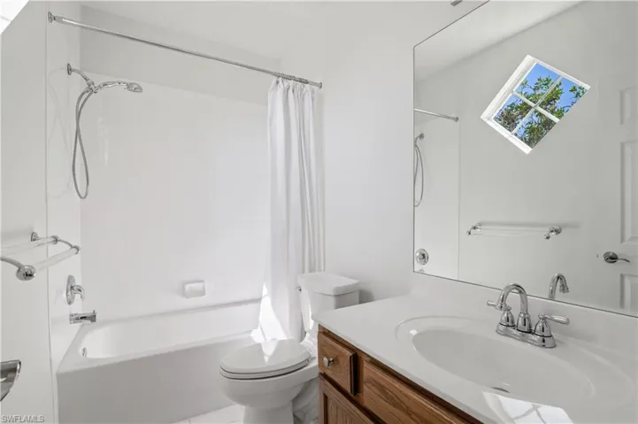 Full bath with vanity, toilet, and shower / bath combination with curtain