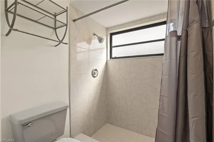 Bathroom featuring toilet and curtained shower