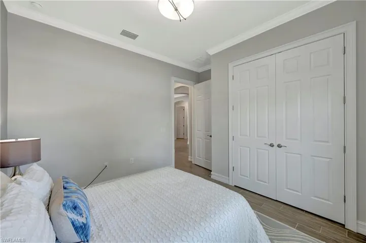 Bedroom with ornamental molding and a closet