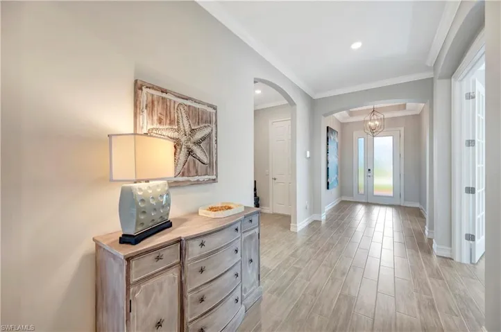 Entrance foyer featuring crown molding and light wood-type flooring