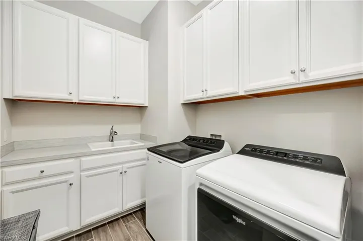 Laundry area featuring cabinets, washing machine and dryer, and sink