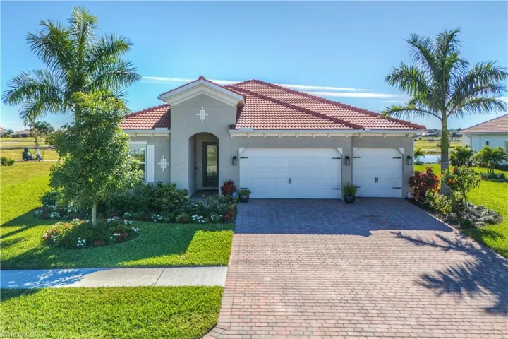 Mediterranean / spanish home with a garage and a front lawn