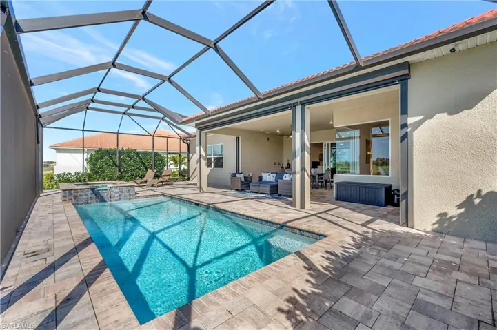 View of swimming pool featuring an in ground hot tub, a lanai, an outdoor hangout area, ceiling fan, and a patio area