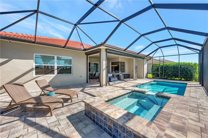 View of swimming pool featuring an in ground hot tub, an outdoor hangout area, glass enclosure, and a patio