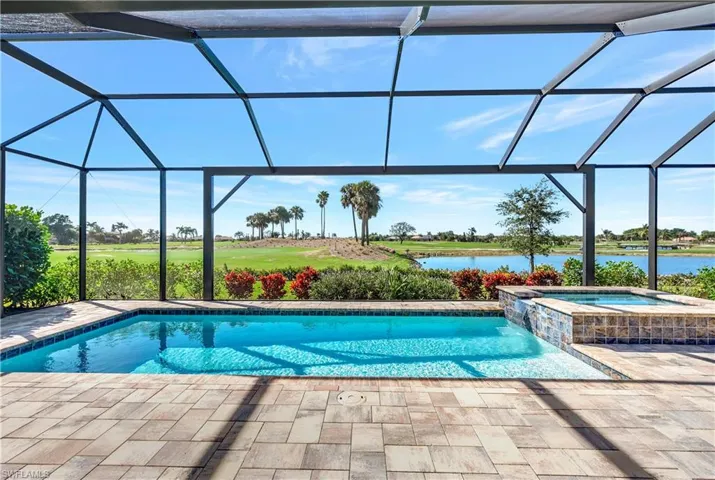 View of swimming pool with a lanai, an in ground hot tub, and a water view