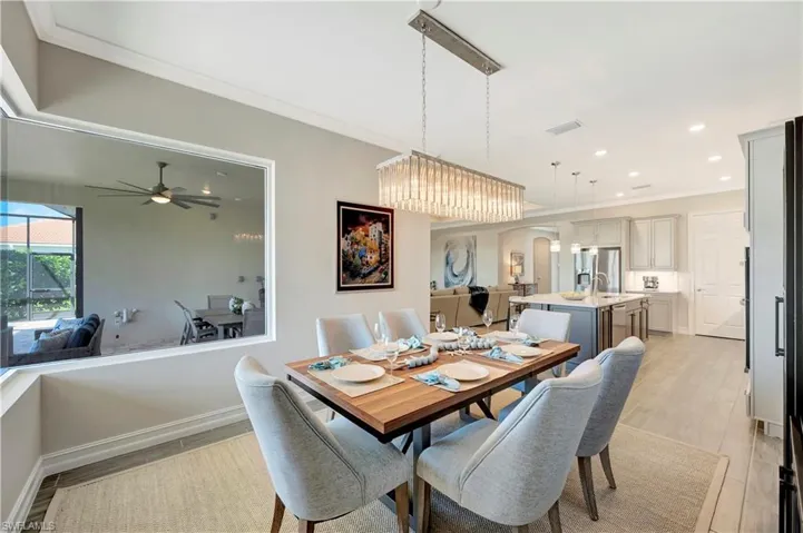 Dining space featuring sink, light hardwood / wood-style flooring, ornamental molding, and ceiling fan