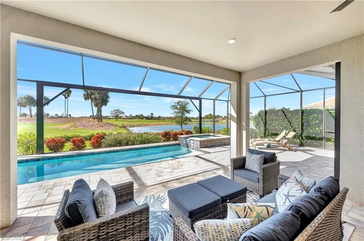 View of swimming pool featuring a patio, outdoor lounge area, an in ground hot tub, a lanai, and a water view