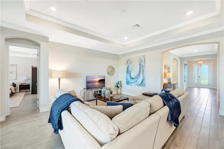 Living room featuring ornamental molding and a raised ceiling
