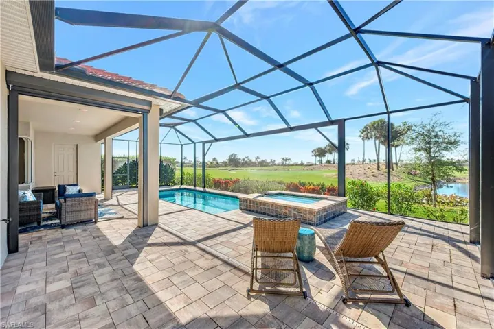 View of swimming pool featuring an outdoor hangout area, an in ground hot tub, a patio, and glass enclosure