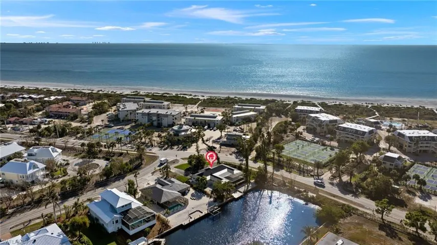 Birds eye view of property featuring a view of the beach and a water view