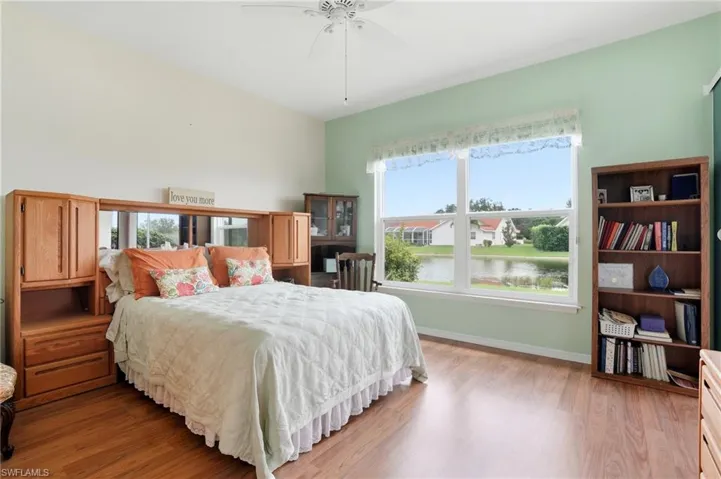 Bedroom featuring light wood-style floors, a water view, and ceiling fan