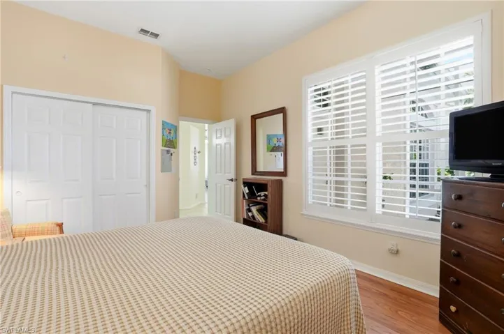 Bedroom with multiple windows, light wood-type flooring, and a closet