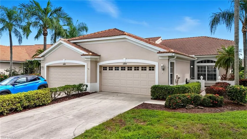 Mediterranean / spanish-style house with stucco siding, driveway, an attached garage, and a tiled roof
