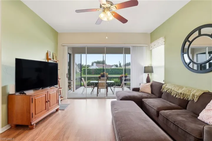 Living room with light wood-type flooring and ceiling fan