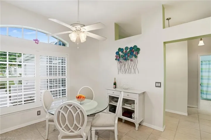Dining area with light tile patterned floors and a ceiling fan