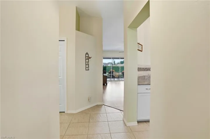 Hallway featuring light tile patterned floors and baseboards