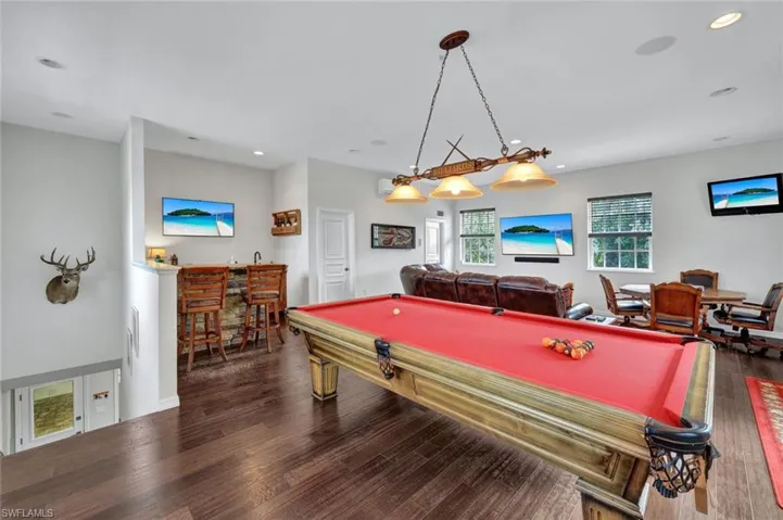Game room featuring billiards, indoor bar, and wood-type flooring