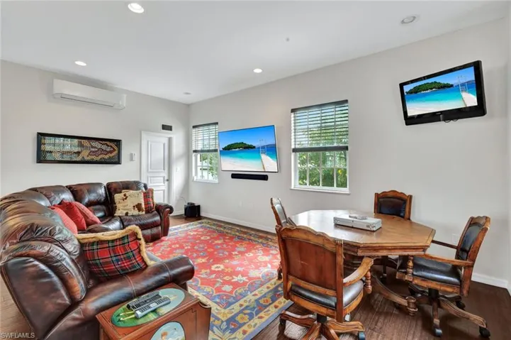 Living room featuring an AC wall unit and hardwood / wood-style floors