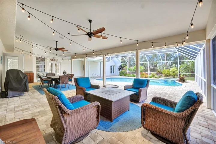 View of patio with ceiling fan, a lanai, a pool with hot tub, and an outdoor hangout area